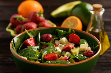Spinach salad with strawberries, avocado and cheese.