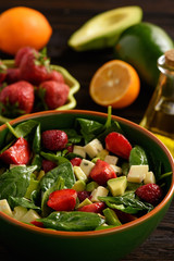 Spinach salad with strawberries, avocado and cheese.