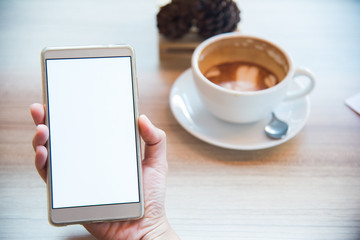 female using smartphone, close-up, coffee cup on the background