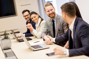 Two business colleagues shaking hands during meeting