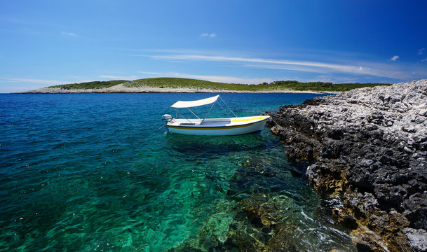 Small boat in crystalline water by Paklinski islands, near Hvar, Croatia