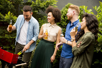 Friends grilling food and enjoying barbecue party