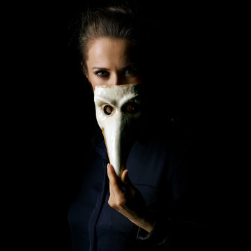 woman isolated on black hiding behind Venetian mask