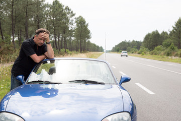 Sad and depressed man near car