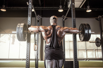 Big black Bodybuilder about to start a heavy barbell squat or lift  