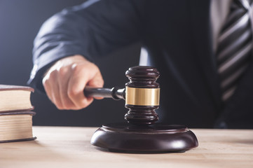 Hand of a businessman holding a hammer or gavel