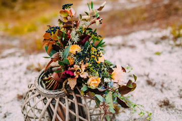 Wedding floristic decoration. The Beautiful bridal bouquet on a wooden stand outdoors.