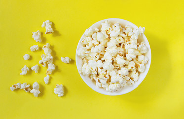 White popcorn in bowl on yellow background, ready-to-eat