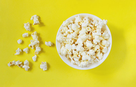 White popcorn in bowl on yellow background, ready-to-eat