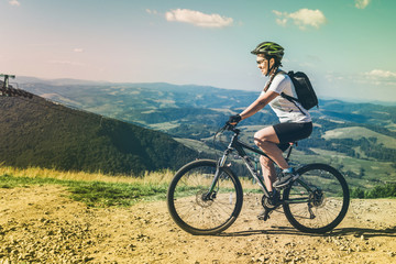 Young woman riding on MTB in mountains