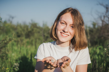 The girl with a butterfly. The woman keeps a butterfly in palms.