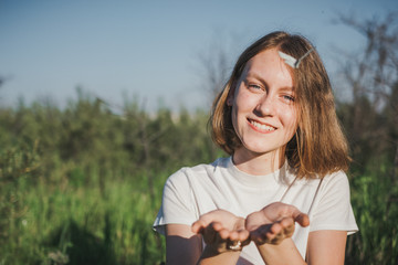 The girl with a butterfly. The woman keeps a butterfly in palms.