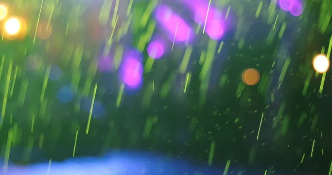 Neon bokeh blur lights through the cold sping rain downpour, urban city background
