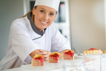 Smiling pastry chef standing in restaurant kitchen