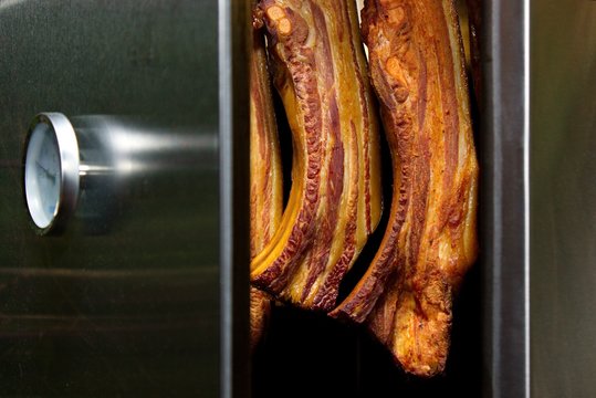 Smoked meat in stainless smokehouse