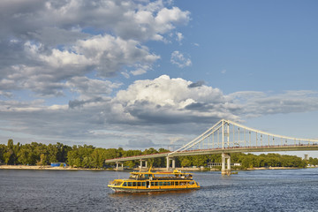 Beautiful clouds over the river. The sun shines brightly. The ships sail along the river.