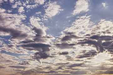 Beautiful clouds in the blue sky on a spring day in the sunlight.