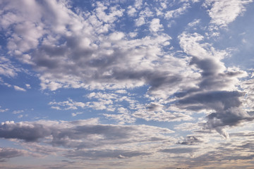 Beautiful clouds in the blue sky on a spring day in the sunlight.