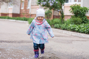 Little girl running into the puddle