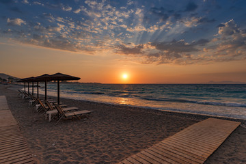 Fototapeta na wymiar Beautiful sunset contre-jour on the sea shore, in a beach resort, with comfortable sunbeds and umbrellas