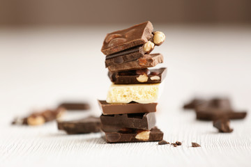 Broken chocolate pieces with nuts on table