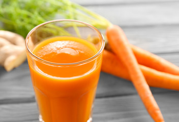 Glass of carrot juice on wooden background, closeup