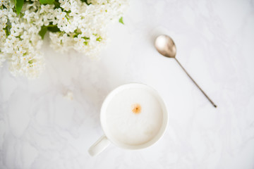 Fototapeta na wymiar cappuccino cup white lilac vintage spoon top view