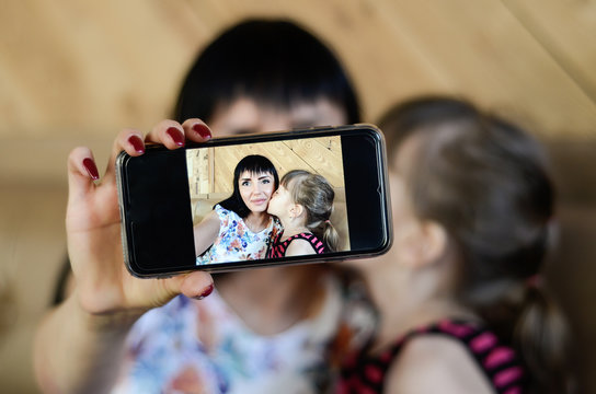 Mother make selfie with her daughter in cafe