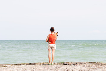 Girl and dog on the pier looking at the sea