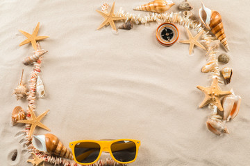Composition with sea shells, starfish, compass and sunglasses on sand. Concept of travel and vacation