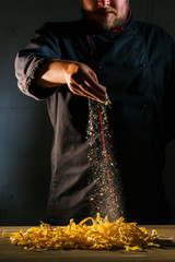 Chef adds wheat flour to the Italian ribbon-shaped pasta, before preparing the dish. Freeze motion...