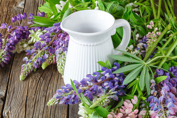 Lupines flowers on wooden and vase