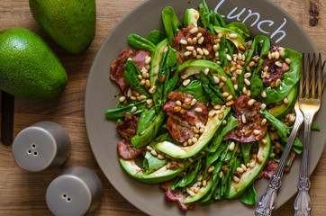 Salad with avocado bacon spinach and pine nuts with balsamic cream