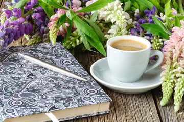 otebook with flower on vintage wooden table