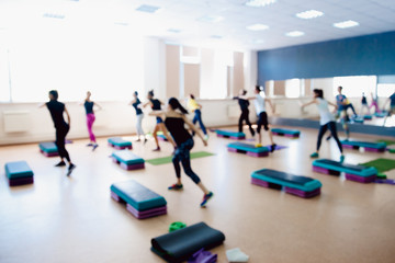 Blurred background of people group of girls playing in yoga and fitness,crossfit in the gym.