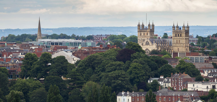 Panoramic view of the city of Exeter. The cathedral and the church of St Michael are well seen. Many large trees and small houses. City center. Devon. England