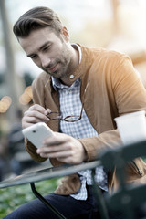 Trendy guy at Bryant park using smartphone