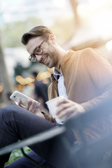 Businessman talking on phone sitting in park