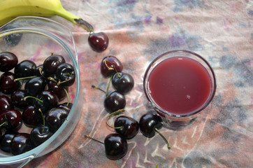 Cerises, bananes et smoothies sur fond chamarré rose et violet