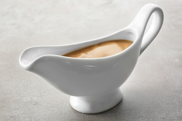 Sauce boat with turkey gravy on light background