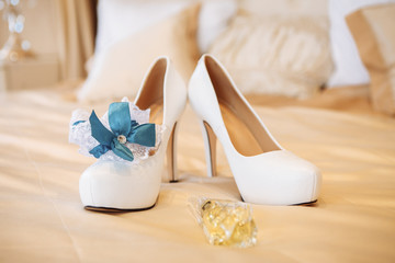 White bride's shoes, garter and wedding rings. selective focus