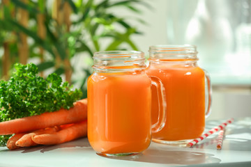 Mason jars of carrot juice  on table
