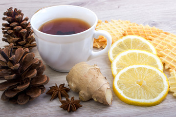Cup of tea with pinecone, badian, ginger, waffles and cinnamon