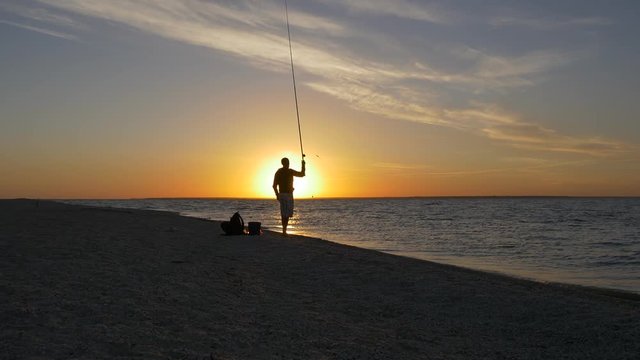 Fisherman throwing fishing tackles at sunrise