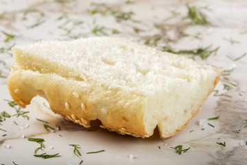 Slice of fresh baguette with sesame with herbs and sea salt