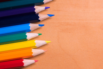Color pencils on wood background close up