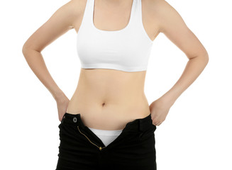 Fototapeta na wymiar Beautiful young woman in undersized pants on white background, closeup. Diet concept
