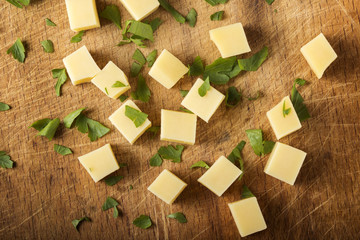Cubes of yellow cheese with herbs stacked randomly