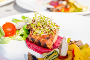 Roasted pork tenderloin with vegetables on a plate.