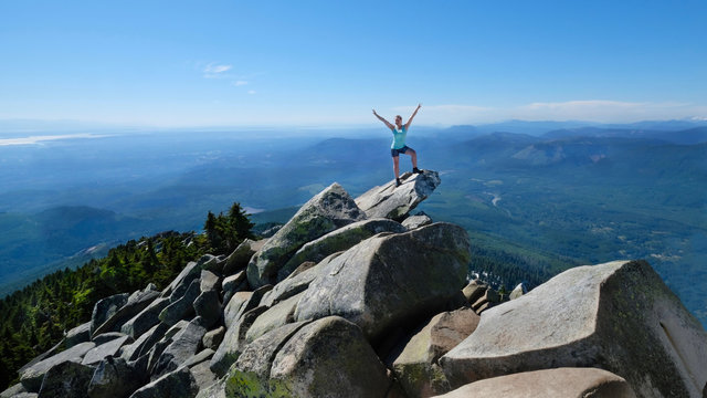Happy woman in sucessfull pose on mountain top with scenic views. Mount Pilchuck. Seattle. Washington. United States. &ndash; Version 2
